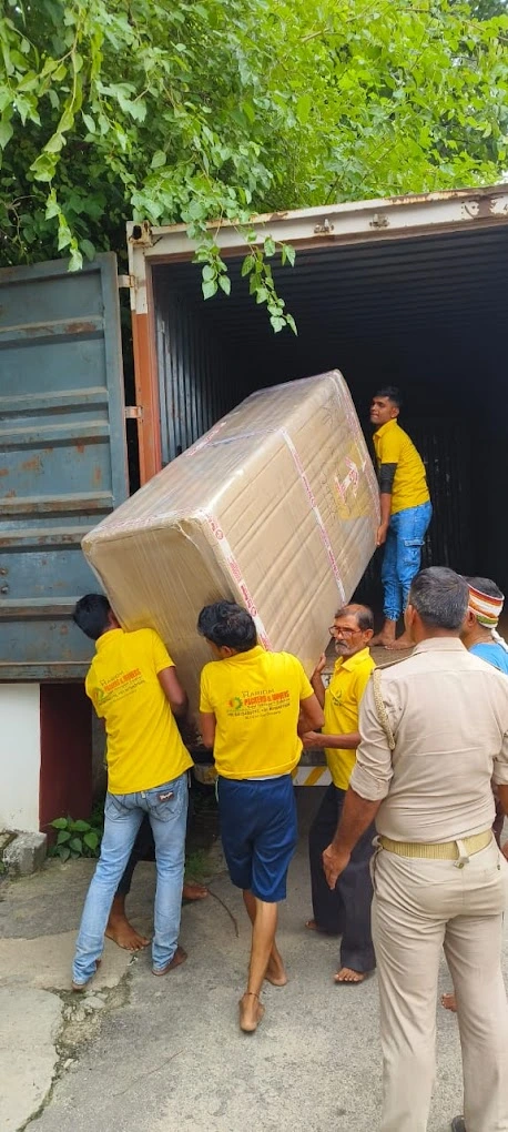 Hariom Packers and Movers team loading household furniture into container truck for relocation